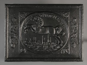 Fireback horse above town with towers, text justitia premo majorum, fire place cast iron, cast Rectangular in the middle an oval