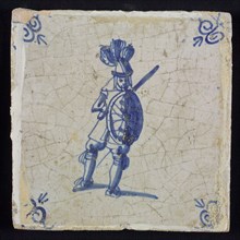 White tile with blue warrior with sword and shield; corner pattern ox head, wall tile tile sculpture ceramic earthenware glaze