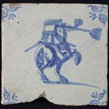 White tile with blue rider with rifle with smoke; corner pattern ox head, wall tile tile sculpture ceramic earthenware glaze