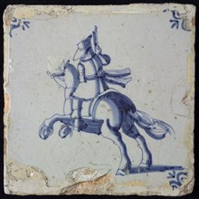 White tile with blue horseman with pistol pointed in air; corner pattern ox head, wall tile tile sculpture ceramic earthenware
