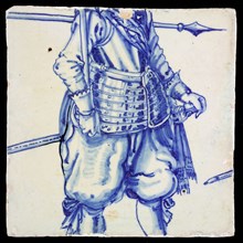 Tile, in blue on white, below an ornamental border, above it two lower legs of soldier with shoes and bows, tile picture footage