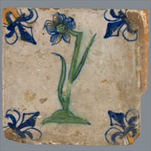 Tile, flower on ground in orange, yellow, green and blue on white, corner pattern french lily, corner point yellow, wall tile