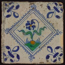 Tile, flower on ground in orange, green and blue on white, inside serrated square, corner pattern french lily, wall tile