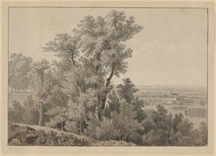 View from a tree-lined slope over a wide valley to a church on the right in the middle ground and a