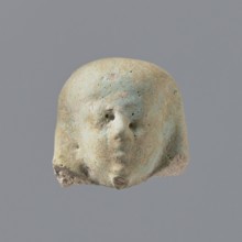 Fragment of a shabti. Fragmentary head of a shabti figurine with indistinct facial features, in a