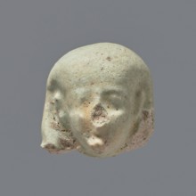 Fragment of a shabti. Head of a shabti figurine with not very carefully rendered facial features,