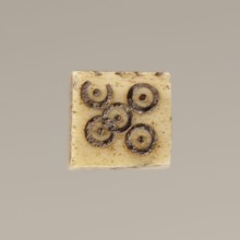 Game die made of animal bone with six unequal sides. Each side is engraved with a number from 1 to