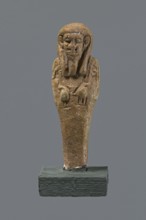 Shabti, mummy-shaped figurine standing on a base, back supported by a pillar/pilaster. Arms crossed
