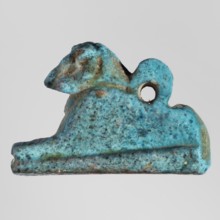 Amulet — ram. Figurine of a ram lying on a flat base, with a loop for hanging on its back. Amulet,