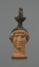 Oinochoe in the shape of a woman's head. Yellowish clay with orange surface, in places shiny black