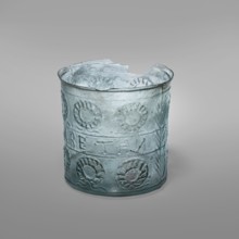 Glass with a wreath motif, Greek inscriptions. Transparent bluish-green glass decorative vessel,