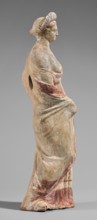 Figurine of a maenad. A young woman standing in a wreath tied with a ribbon is dressed in a chiton