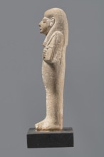Ushabti, Mummy-shaped figurine made of limestone. Arms crossed on the chest, the right over the