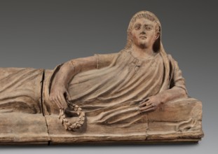 Sarcophagus lid;, The deceased is shown in a semi-reclining position, resting his left forearm on a