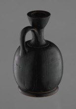 Black-finished aryballoid lekythos coated with black varnish. The medium, flat foot flows directly