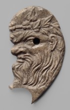 Decoration in the shape of the head of Silenus. Relief appliqué of the head of Silenus, depicted in