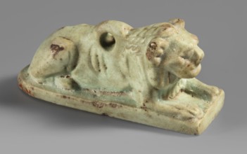 Amulet in the shape of a lion lying on a flat base, with paws stretched forward, head facing
