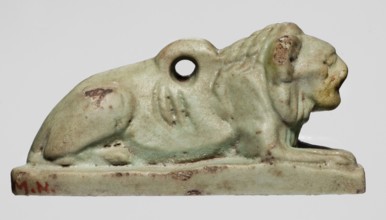 Amulet in the shape of a lion lying on a flat base, with paws stretched forward, head facing