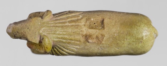 Amulet in the shape of a ram standing on a stand with curled horns and a short beard. The fur