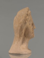 Votive female head, Female head wearing a wreath, from under which lush locks of hair curl down the
