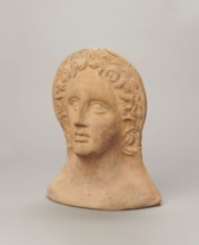 Votive female head;, female head wearing a wreath, from under which lush locks of hair curl down