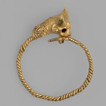 Earring decorated with a bull's head. Earring with a round ring twisted from two wires, pointed at