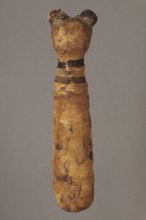 Cat mummy decorated with a meander made of white and brown bandages. Cat mummy, linen fabrics;