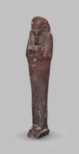 Ushabti, A shabti figurine dressed in a shroud stands on a base. On the head is a smooth wig,