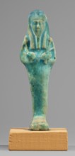 Ushabti. Mummy-shaped funerary figurine, standing on a base, supported at the back by a flat