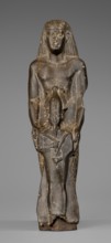 Figurine of a priest with a statuette of the god Osiris. The priest is shown standing, holding in