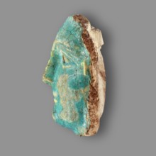 Fragment of a figurine. Oval male face with a protruding chin, small mouth, straight nose, and
