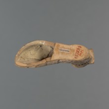 Foot-shaped aryballos, aryballos, antique vessel. Yellow-orange clay with mica; matte black engobe