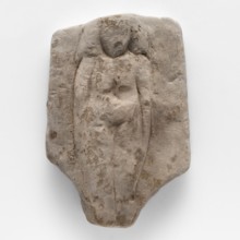 Fragment of a figurine of a woman on a bed. Flat figurine of a concubine resting on a plate