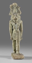 Amulet - god Mahes. Figurine of a striding lion-headed male deity wearing an atef crown, dressed in