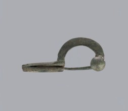 Onion-shaped fibula, Italy. Bronze fibula with a hinged structure and an arched ring made from a