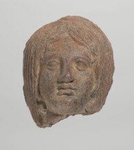 Female votive head, Female head with long, straight hair falling to the shoulders. Neck partially