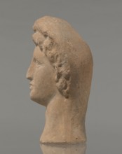 Female votive head, Female head in a wreath, slightly tilted to the right shoulder. Under the
