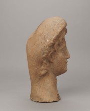 Female votive head. Female head in a wreath, slightly tilted to the right shoulder. Under the