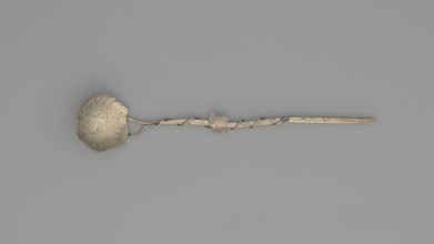 Decorative spoon with a flat round scoop with irregular edges decorated on both sides with engraved