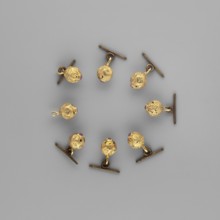 Buttons for a zupan with clasps. Nearly spherical, polygonal buttons with engraved four-leaf