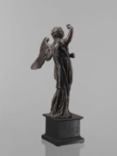 Statue - Angel. Figure of a standing angel with his right hand raised, the other raised to chest