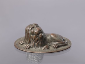 Jelly mold, repoussé copper sheet in the form of a lying lion; raised head allows contents to be