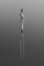 Fork. Two-pronged steel fork with a silver handle in the form of a full-plastic female herm.