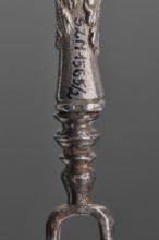 Fork. Two-pronged steel fork with a silver handle shaped as a full-plastic female herm, decorated