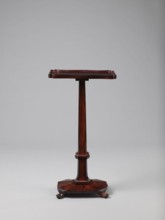 Pedestal table with a rectangular top with a wavy-cut edge and a low wooden gallery, supported by