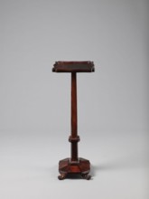 Pedestal table with a rectangular top with a wavy-cut edge and a low wooden gallery, supported by