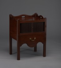 Bedside table with toilet, with a tambour door in the upper section and a pull-out section below