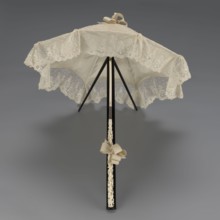 Women's umbrella made of white lace. Its canopy is trimmed with cream silk at the bottom, which