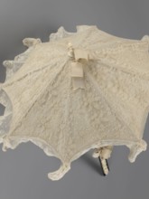 Women's umbrella made of white lace. Its canopy is trimmed with cream silk at the bottom, which