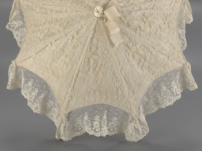 Women's umbrella made of white lace. Its canopy is trimmed with cream silk at the bottom, which